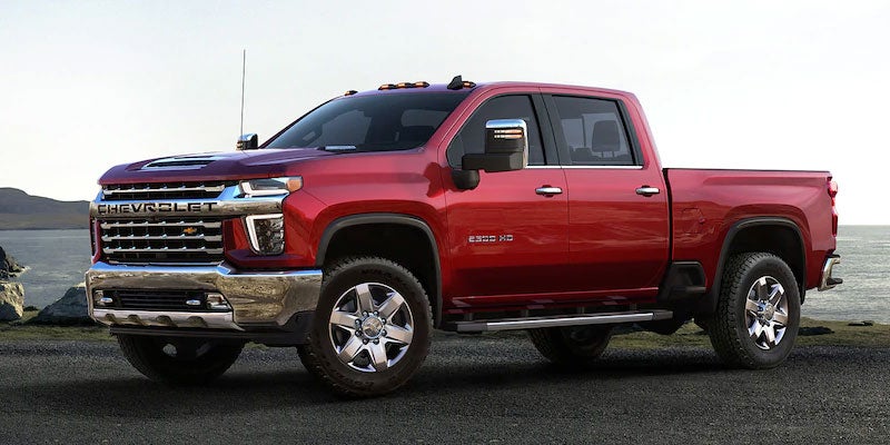 Red Chevrolet Silverado parked beside the sea